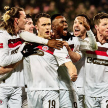 Spieler des FC St. Pauli feiern ausgelassen ein Tor, das ihnen das Glück der anderen beschert.