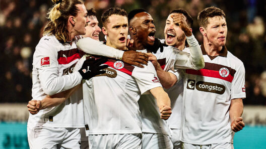 Spieler des FC St. Pauli feiern ausgelassen ein Tor, das ihnen das Glück der anderen beschert.