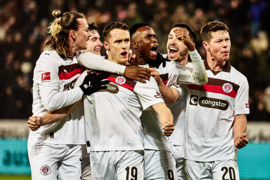 Spieler des FC St. Pauli feiern ausgelassen ein Tor, das ihnen das Glück der anderen beschert.