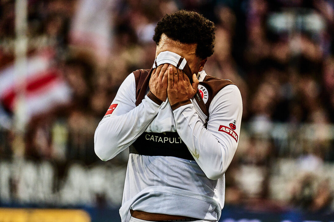 Ein Spieler des FC St. Pauli verdeckt frustriert sein Gesicht