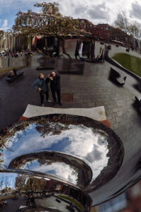 Ein Paar posiert mit einem Spiegelobjekt in Amsterdam, während Wolken und Bäume reflektiert werden. | © Stefan Groenveld