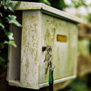 Ein alter Briefkasten vor Pflanzen mit Schlüssel - ein Sinnbild für die Sicherheit von eMail-Adressen